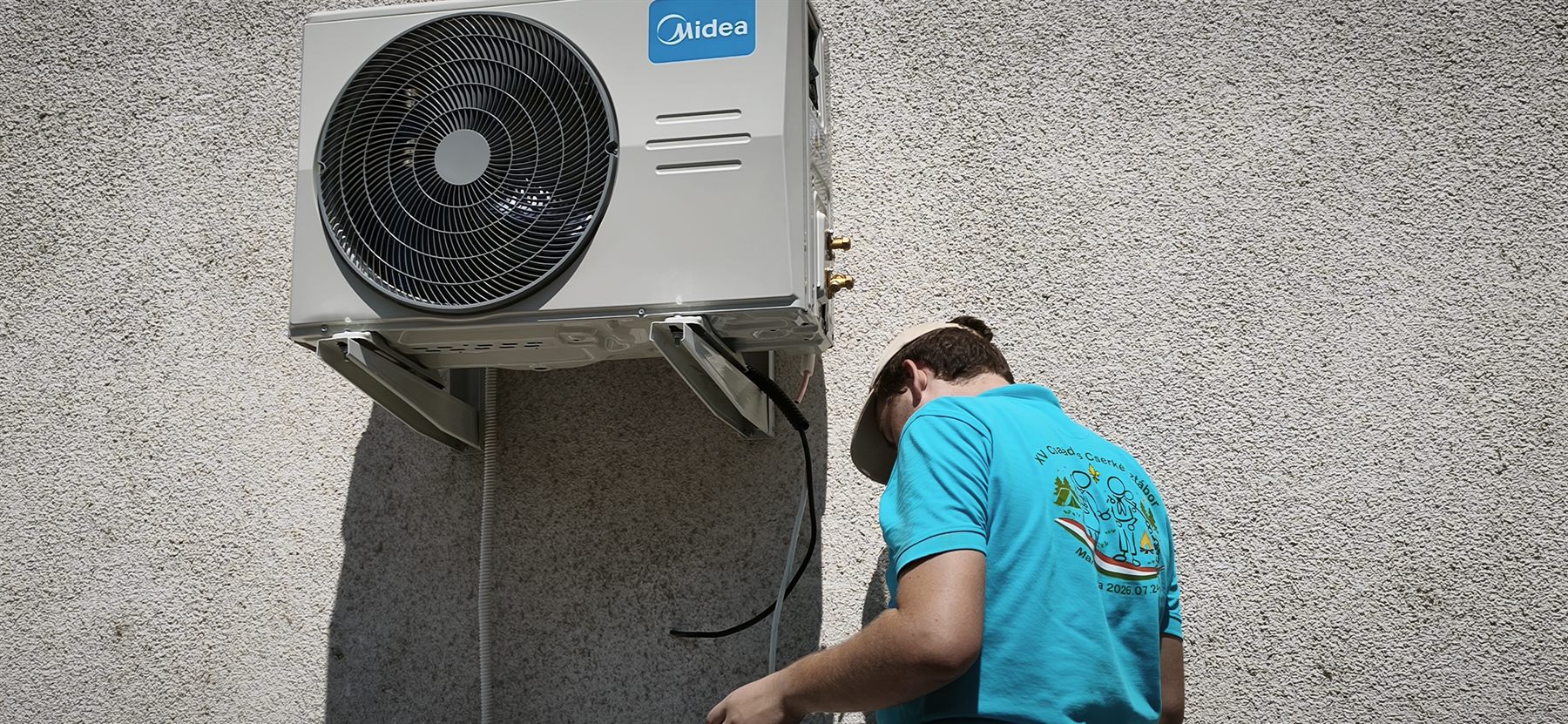 Precízna montáž vonkajšieho klimatizačného kompresora Midea na fasádu